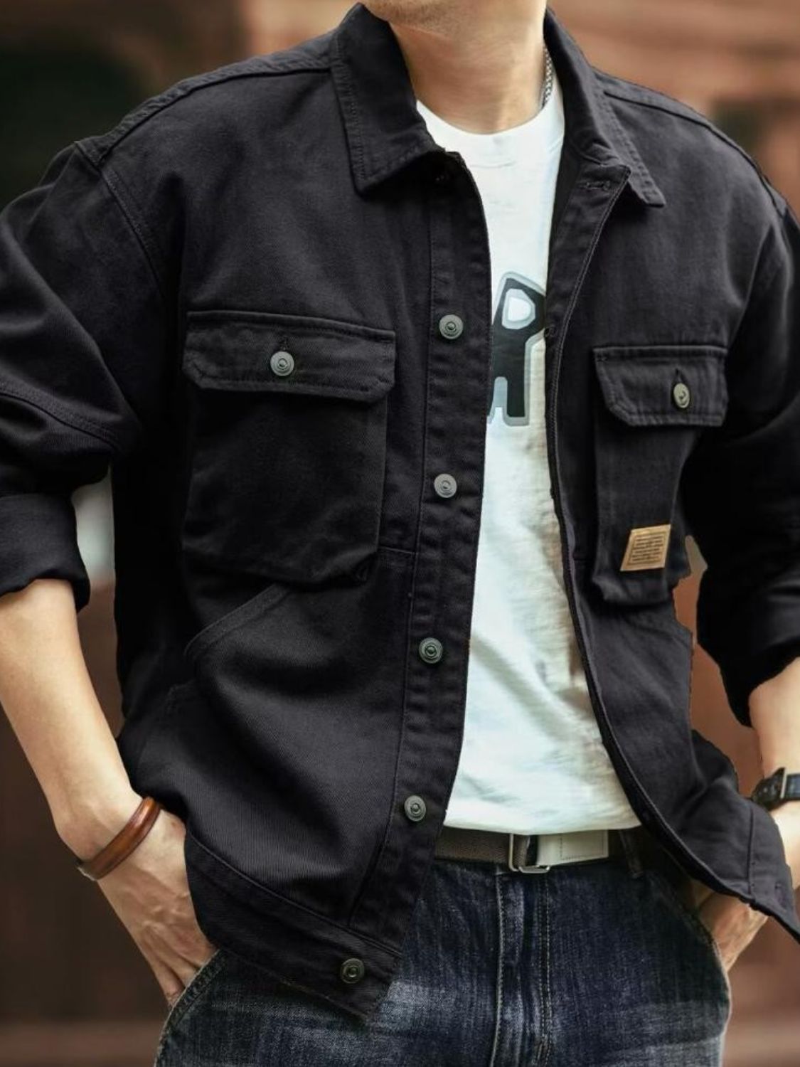 A man wearing a brown washed collared neck cargo jacket with button-up front and multiple pockets.