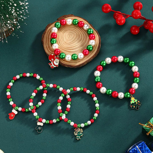 Christmas-themed beaded bracelets with Santa Claus and snowman charms on a green surface.