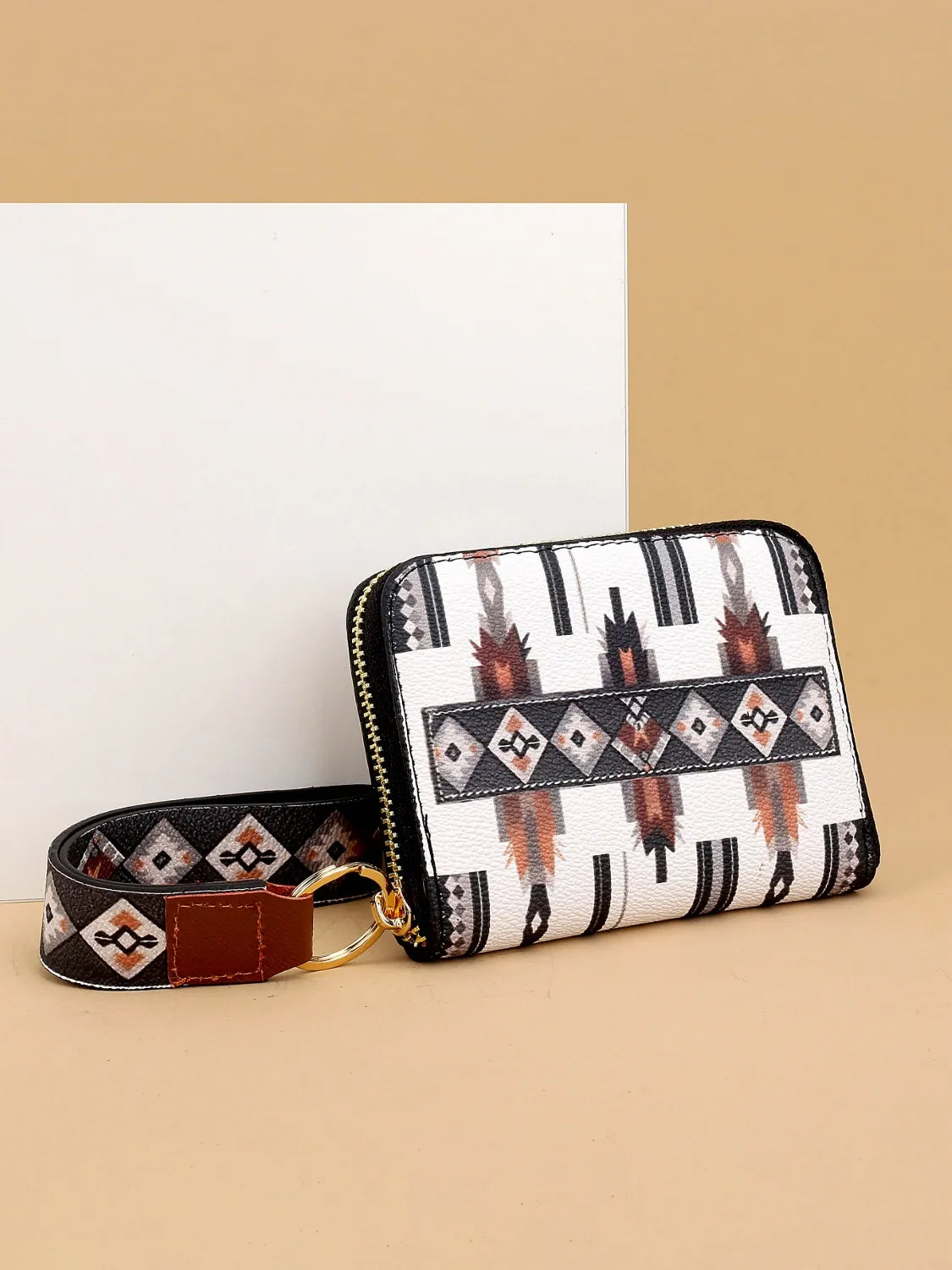 Patterned wallet with strap on a beige background