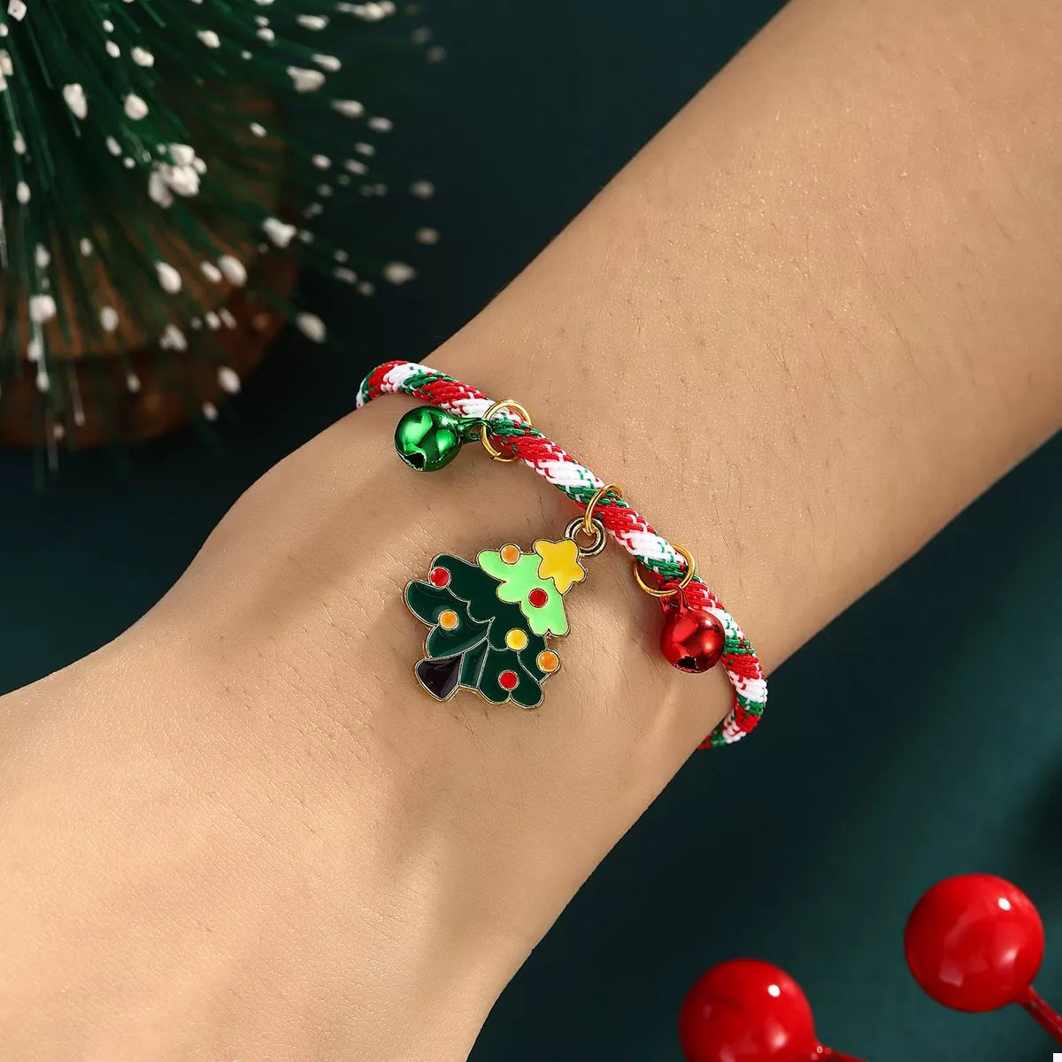 Bracelet with Christmas-themed charms on a wrist against a dark background