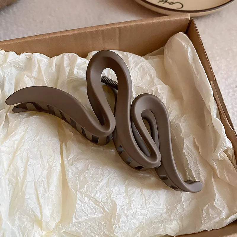 Brown hair clip on crumpled white paper inside a cardboard box