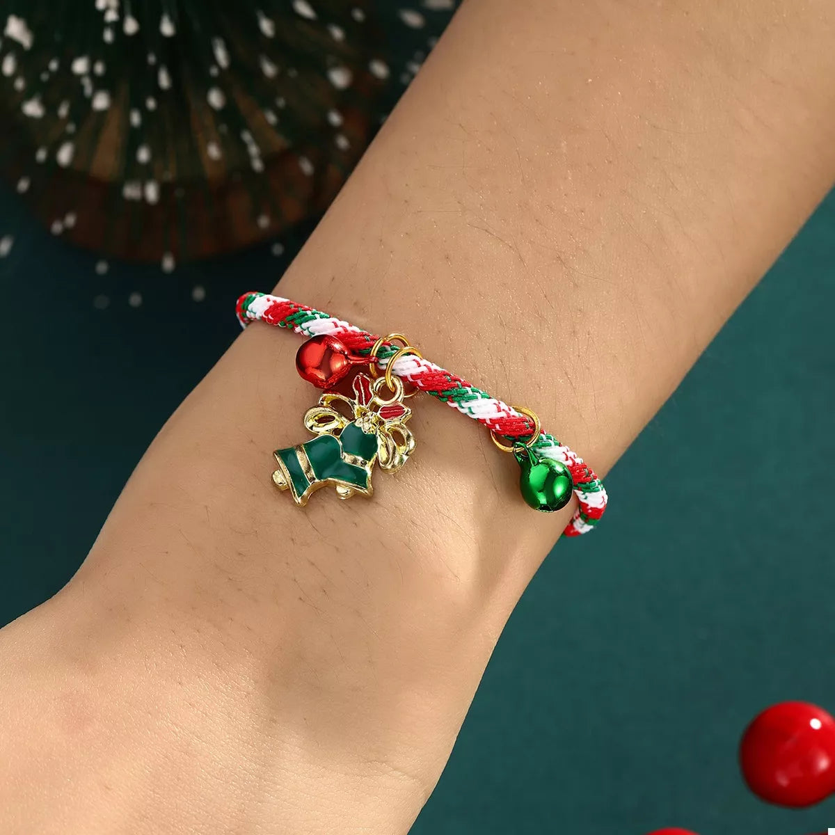 Bracelet with candy cane and reindeer charms on a wrist against a dark background