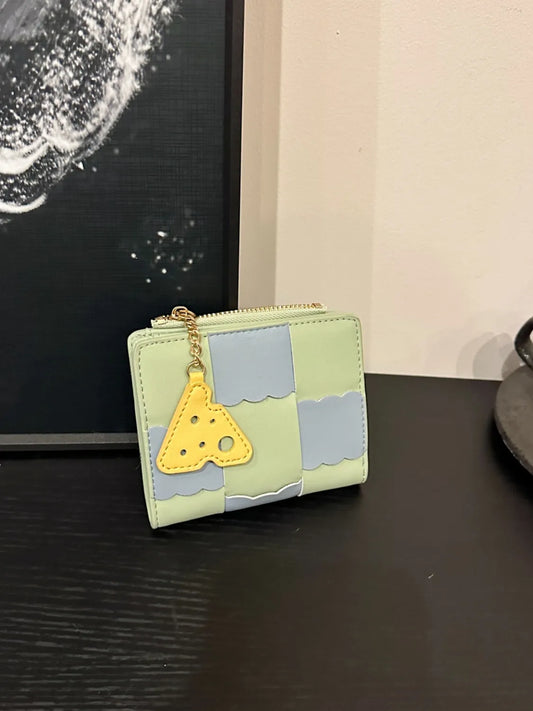 Small wallet with a yellow triangle charm on a dark surface