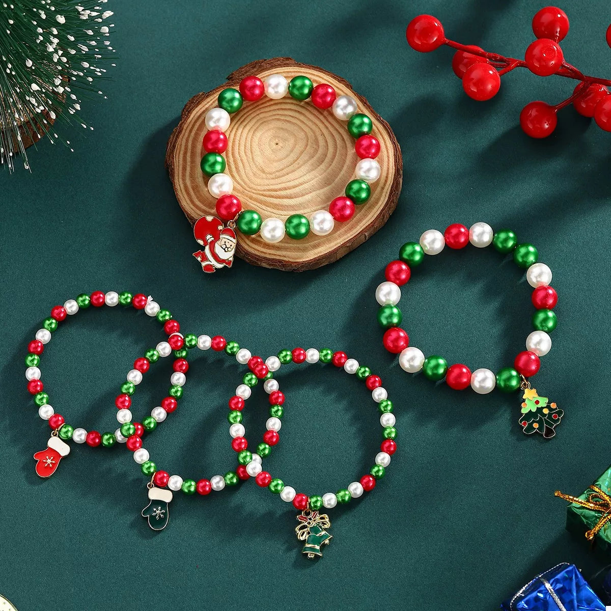 Christmas-themed beaded bracelets with Santa Claus and snowman charms on a green surface.