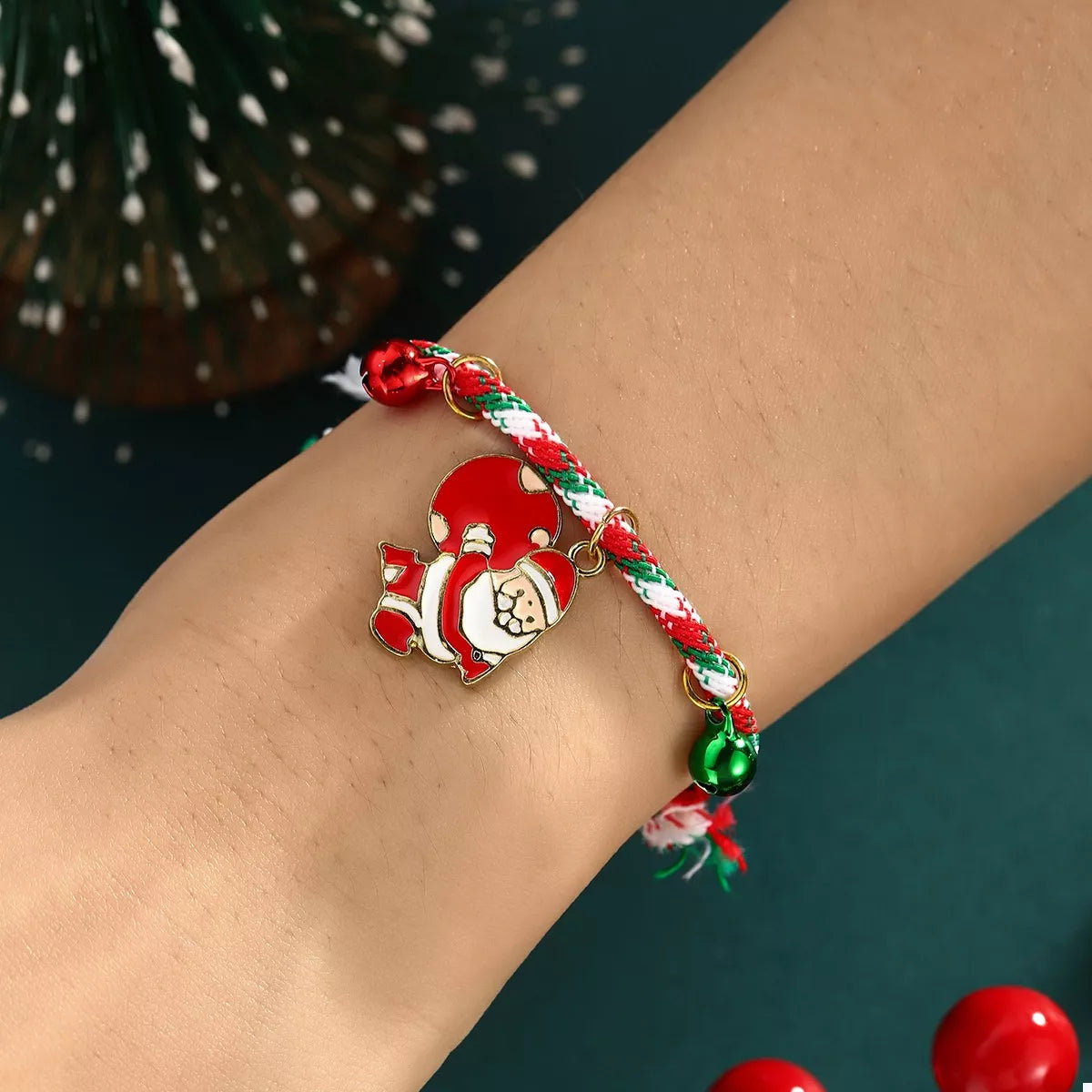Bracelet with Santa Claus charm on a wrist against a dark background