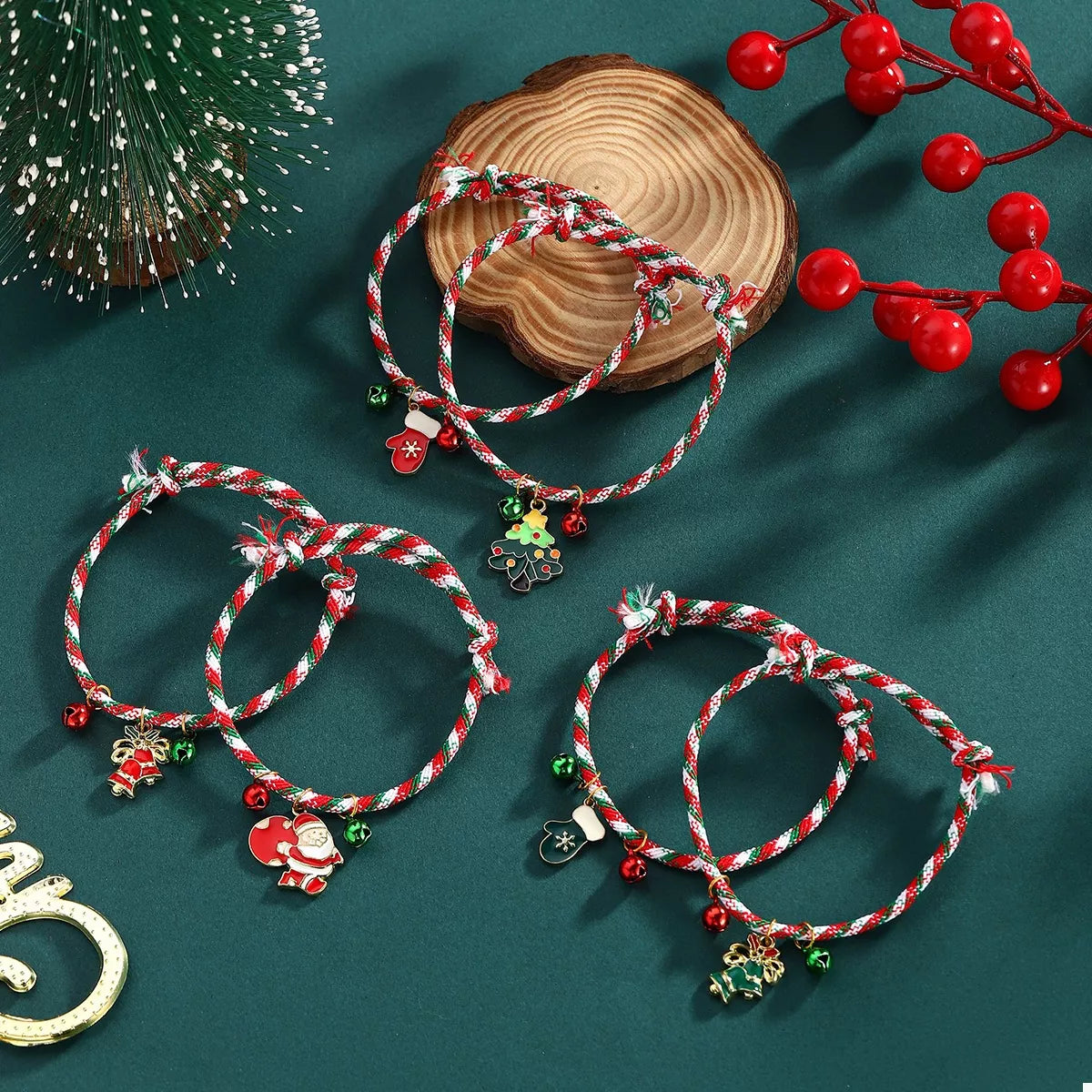 Set of Christmas-themed bracelets with charms on a green surface with decorative elements.