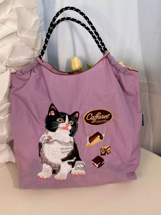 Purple tote bag with a cat illustration and 'Caffaree' branding on a light background