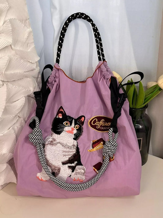 Purple drawstring bag with a cat design and 'Caffarel' branding on a white surface.